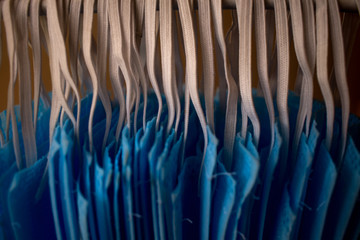 Corona Virus pandemic masks being hanged on a cloth rod after cleaning. Reusable blue colored face masks