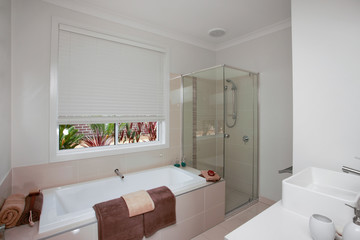 Fototapeta na wymiar A white bathroom with brown bath towels