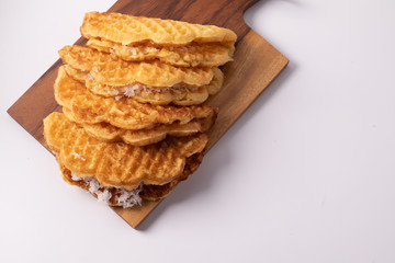 Coconut waffle on a wooden cutting board, white background