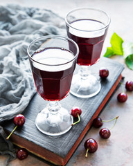 Cherry liqueur in a glass and fresh fruits