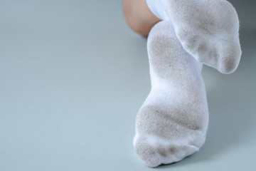 Pair of child feet in dirty stained white socks. dirty socks Pair of child feet in dirty stained...