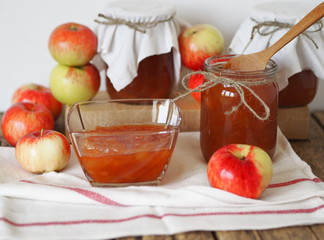Homemade jams for future use.Amber apple jam in a salad bowl on a wooden table with jars of jam in the background.