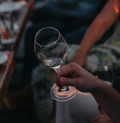 Glass of white sparkling wine at a summer tasting in the hand of a model.