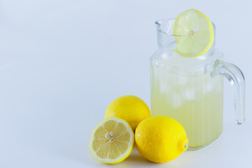 Lemon juice with ice in a glass jug Decorated with lemon slices With lemon cubes cut in half On a...