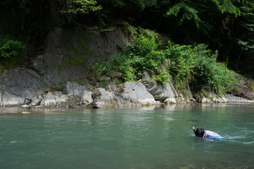 川遊びを楽しむ男性