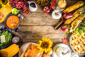 Happy Thanksgiving concept. Thanksgiving day celebration dinner setting with traditional meal and food - green beans, mashed potatoes, cranberry sauce, pumpkin soup, autumn fruits, vegetables