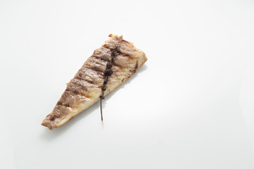 Fish fried on the grill and served on a plate with fresh vegetables