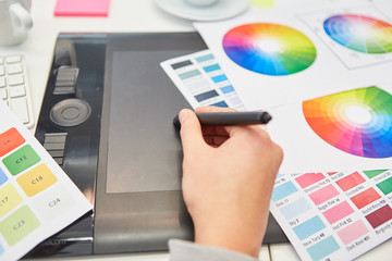 Hand from graphic designer with pen and tablet