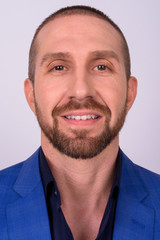 Fototapeta premium Portrait of happy handsome bald bearded businessman in suit