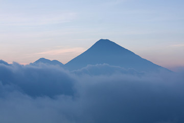 Fototapeta premium Volcano next to Pacaya surrounded by clouds in the evening, Guatemala