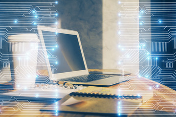 Computer on desktop in office with technology theme hologram. Double exposure. Tech concept.