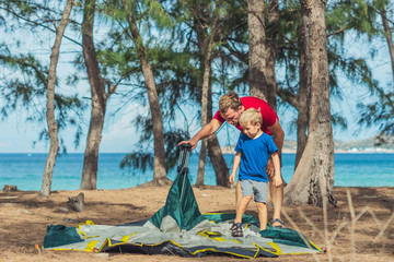 Camping people outdoor lifestyle tourists put up set up green grey campsite summer forest near...