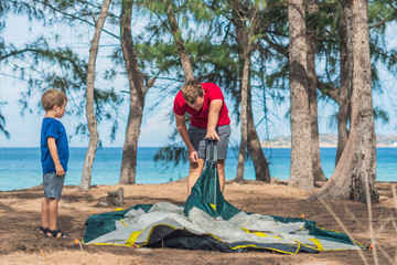 Camping people outdoor lifestyle tourists put up set up green grey campsite summer forest near...
