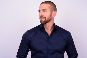 Portrait of handsome bald bearded businessman thinking