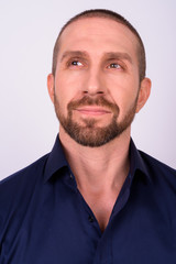 Obraz premium Face of handsome bald bearded businessman thinking and looking up