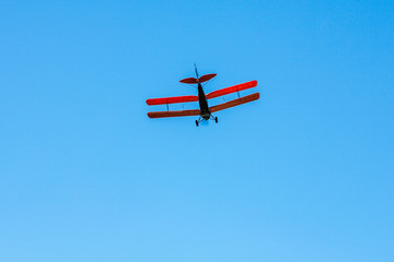 Tiger moth plane flying on the blue sky