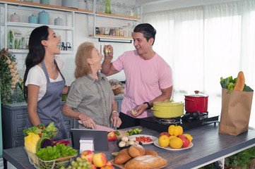 Happy daughter, son or couples and mother cooks a organic homemade meal in a family kitchen together with smile