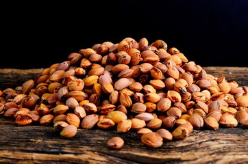 stack of cherry stones on an old wooden board, black background
