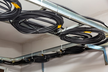 Cable management. Working wires, black cables wound into a coil, a circle. Rings of coiled wires,...