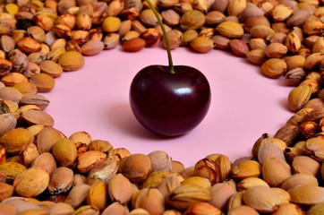 many cherry stones on a pink plate and one cherry