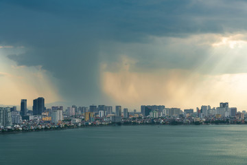 Fototapeta premium Hanoi cityscape with skyline view during sunset period with dark clouds at West Lake ( Ho Tay ) in 2020