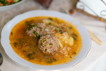 Soup with meatballs in a plate on the table