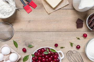 Top view raw ingredients for cooking cherry pie on wooden background with copy space. Bakery background.