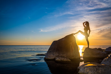 Fototapeta na wymiar Slim female stretching during sunset