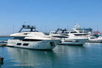 Beautiful view of luxury private yachts in the tropical sea on a sunny day. Ships and boats are moored at the pier..