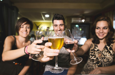 Three friends in restaurant with alcohol cups making toast to the view