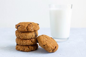 Oat cookies with raisin and glass of milk on light background with copy space. Fresh breakfast concept.