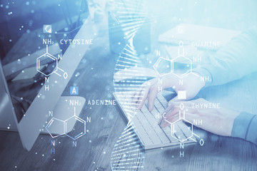 DNA hologram with businessman working on computer on background. Concept of bioengineering. Double exposure.