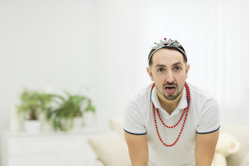 Close up portrait of young man with beard sticking out his tongue.