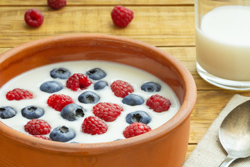 Yogurt with blueberries, raspberries, blackberries, flax seeds on a wood background. Served vegetarian dish. Healthy breakfast, healthy food. Background for menu of restaurants, cafe.