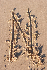 N - Alphabet letter written on sand 