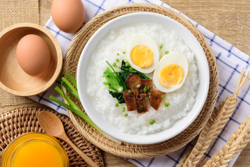 Asian breakfast food, Rice soup with boiled egg, grilled mushroom and spinach in bowl