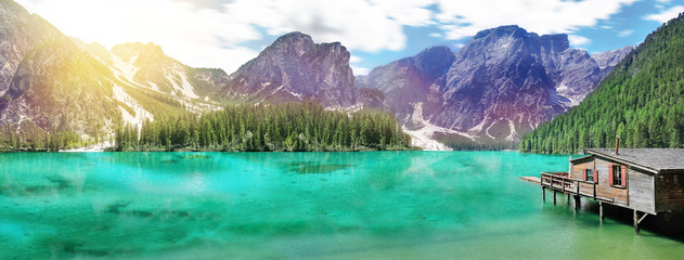 View from the shore of the turquoise lake to the high mountains and the forest.