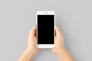 Woman’s hand with blue nails using smart phone with empty screen. Top view. Close up