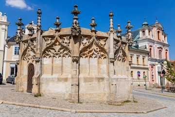 Obraz premium Stone Fountain in historical Town Center with cobblestone road, old style buildings, blue sky, Kutna Hora, Central Bohemian Region, Czech Republic