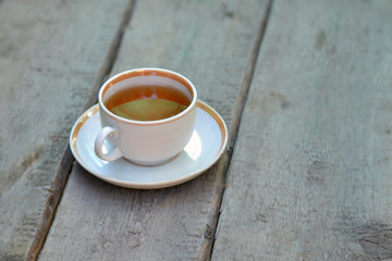 A Cup of tea on a wooden surface for Breakfast. Close up.