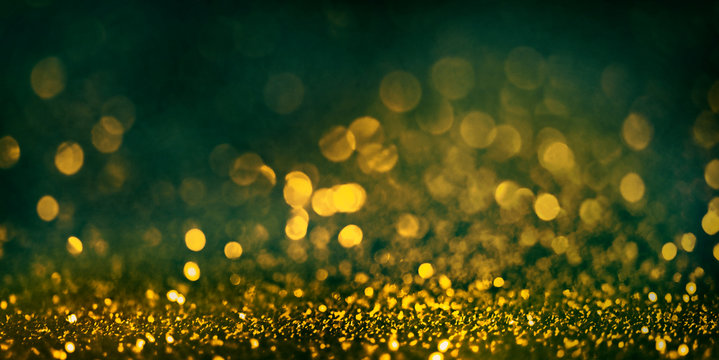 Abstract blur golden glitter border on black background. Luxury card design for new year, christmas and wedding celebration. Party bokeh sparkle confetti textured layout