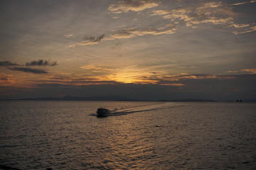 Fototapeta na wymiar Beautiful sunset over sea with a small boat, Thailand
