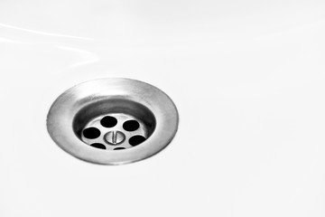 White bathroom sink with metal siphon.