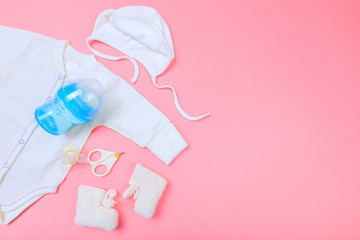 Baby concept. Baby cloth and goods on pastel pink background. Place for text. View from above. Flat...