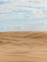 Two people at the distance on the desert.