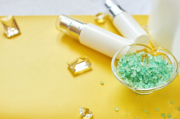 Cosmetic mock up white and blue bottles. blue sea salt in a glass stand on a white background in a yellow frame. Flat lay top view copy space. Natural skincare beauty product concept