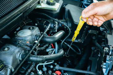 Man is repairing a car. Instruments in hands. Open bonnet of the vehicle.