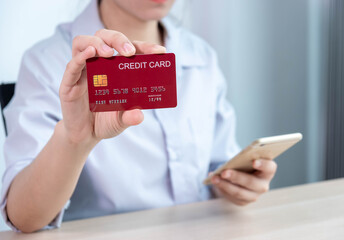 Online payment,women hands holding a credit card and using smart phone for online shopping