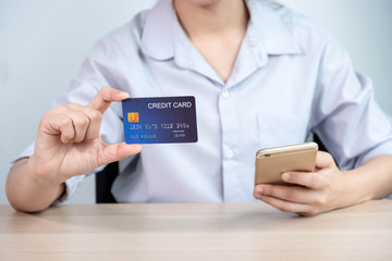 Online payment,women hands holding a credit card and using smart phone for online shopping