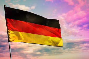Fluttering Germany flag on colorful cloudy sky background. Prosperity concept.